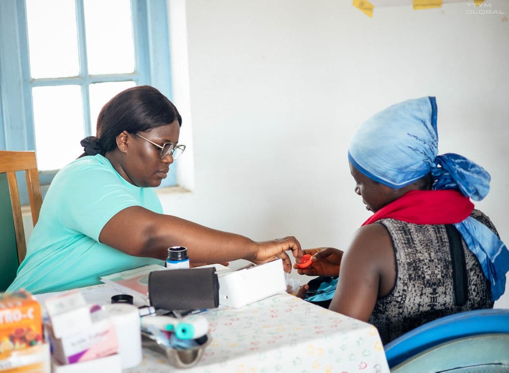 Sarah administering health services to pregnant woman