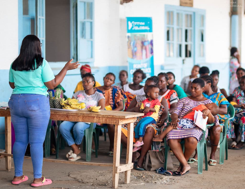 Sarah talking with the prenant women outside