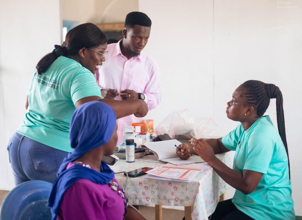 Sarah and two others taking care of patient during consultation