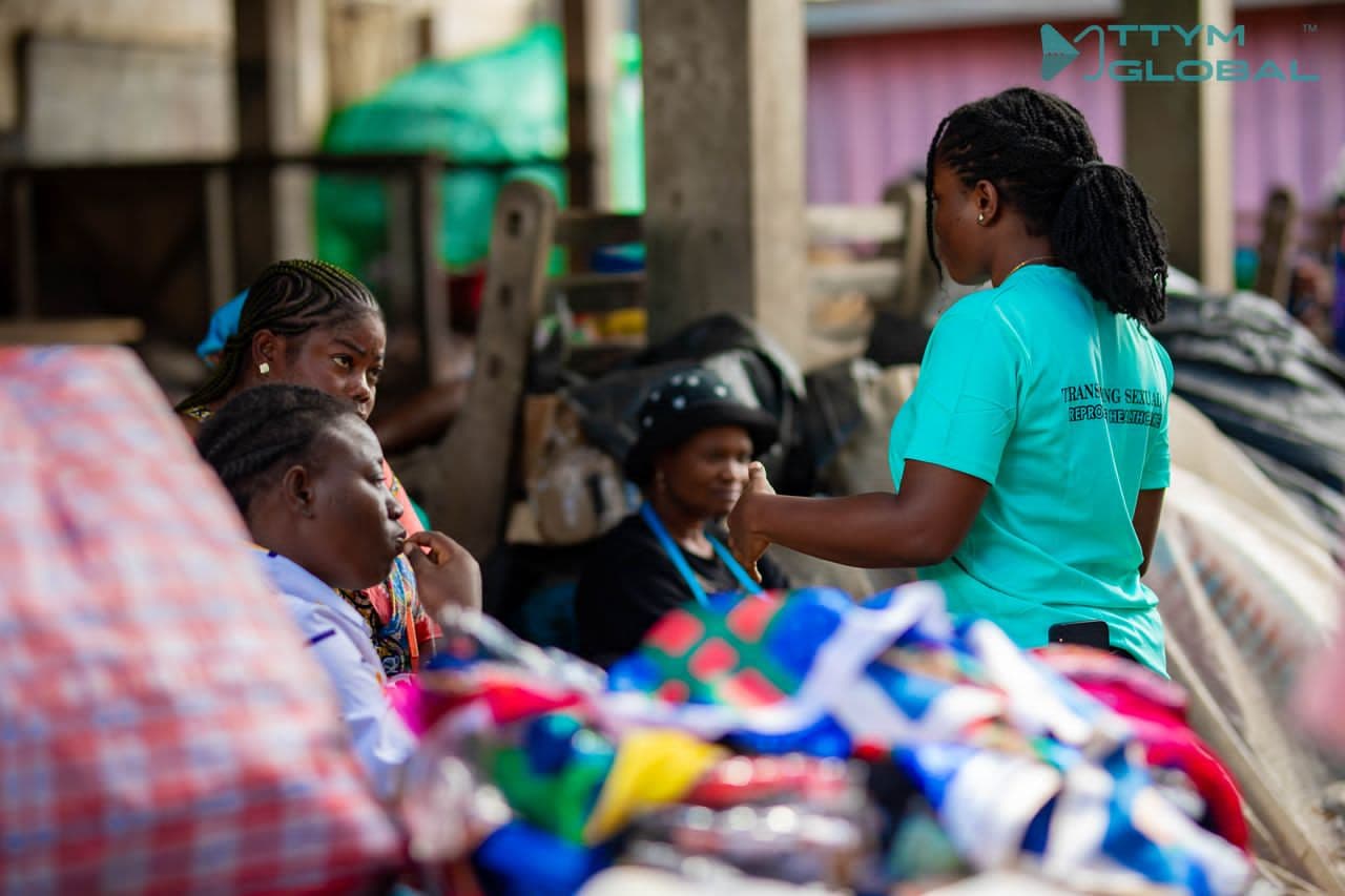 TTYM employee educating market women 